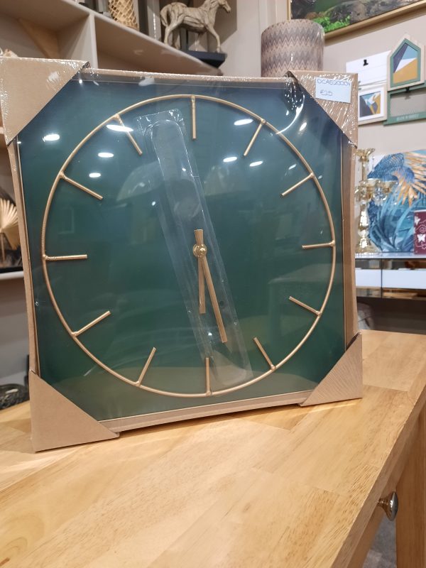 green clock with gold detail in a cardboard box with a clear plastic front cover