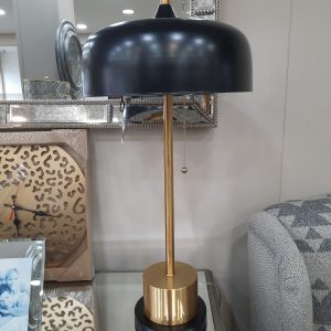 a metal lamp with a black shade and a gold base. it features a pull string