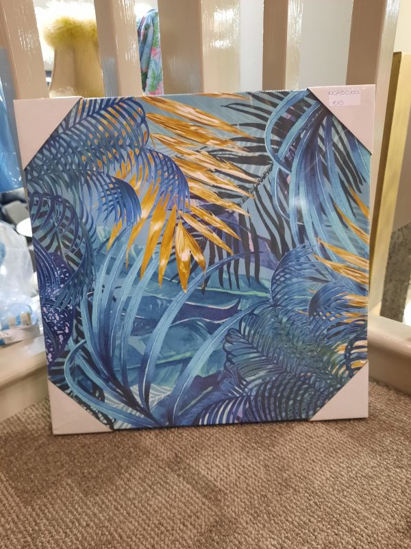 a canvas picture with images of leaves in a jungle style. mostly blue with a small bit of gold