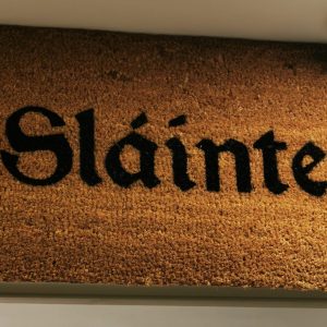 a brown doormat with bold black writing which says sláinte