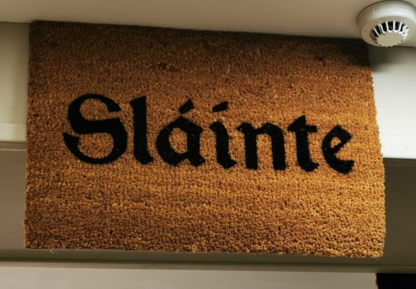 a brown doormat with bold black writing which says sláinte