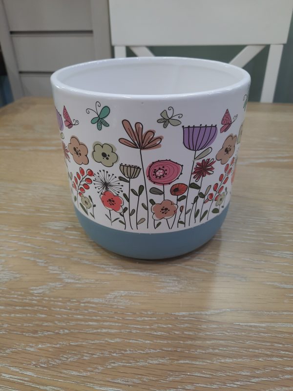 an image of a small ceramic flowerpot with a floral design