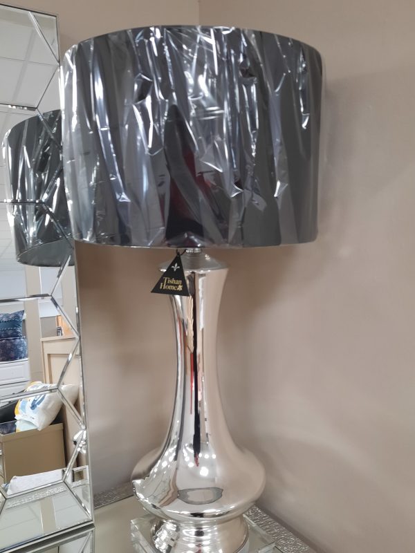 an image of a tall table lamp with a silver base and a black shade