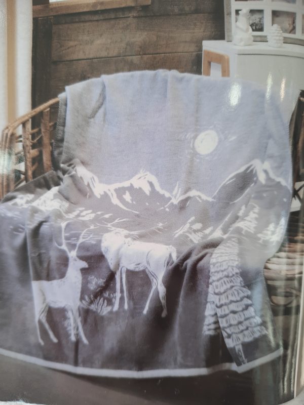 an image of a grey christmas throw with mountains and reindeer on it